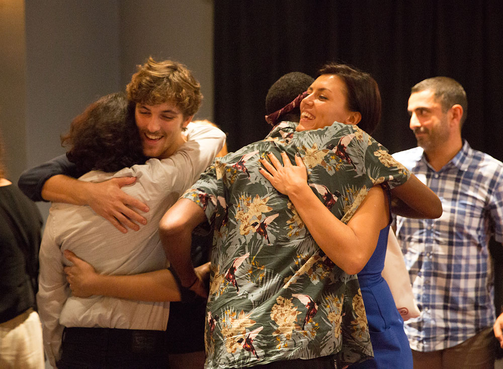 group of people hugging at the 2016 nyfa fall film commencement ceremony