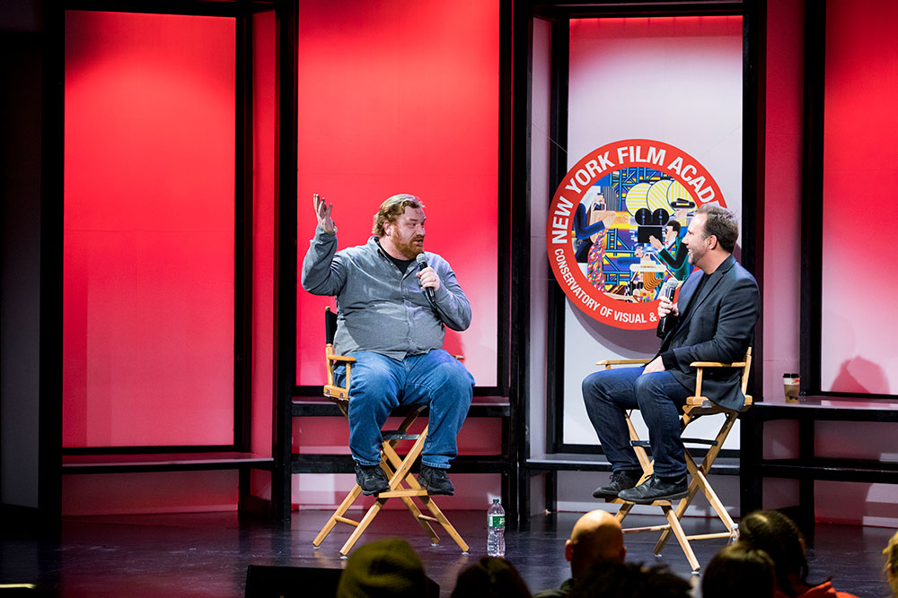 NYFA Conservatory of Visual & Performing Arts acting screening Q&A with two men in directors chairs on stage answering questions in a mic. 