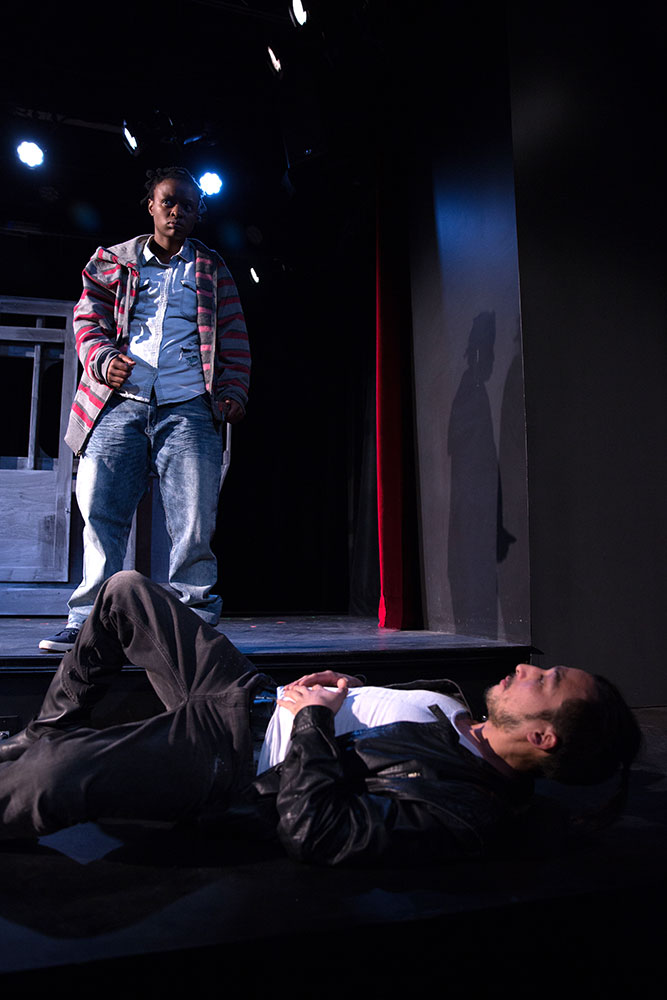 NYFA And Then They Fell actor standing over actor laying on his back on stage.