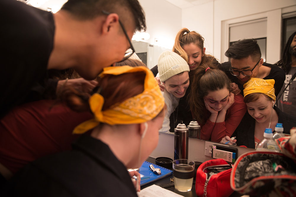 NYFA And Then They Fell students working together in front of makeup mirror.