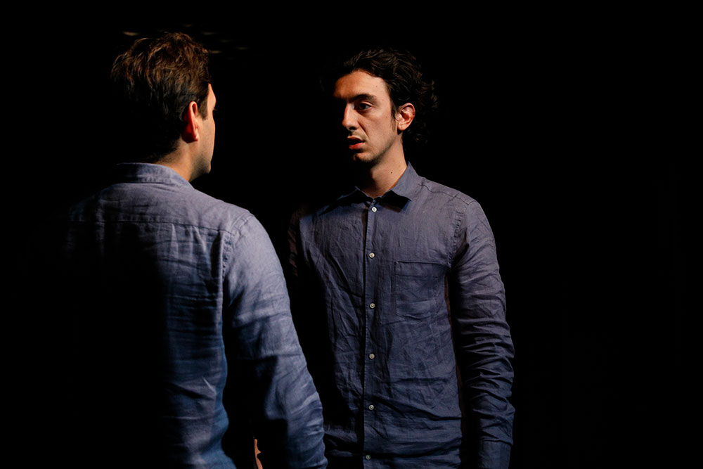 NYFA LA play two student actors staring at each other on black box theater stage.