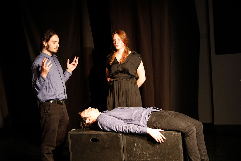 NYFA LA play student actors in black box theater with one student laying down.