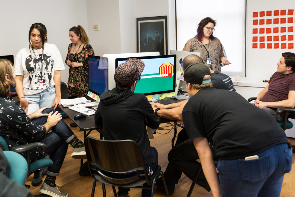 Group of people gathered around computers