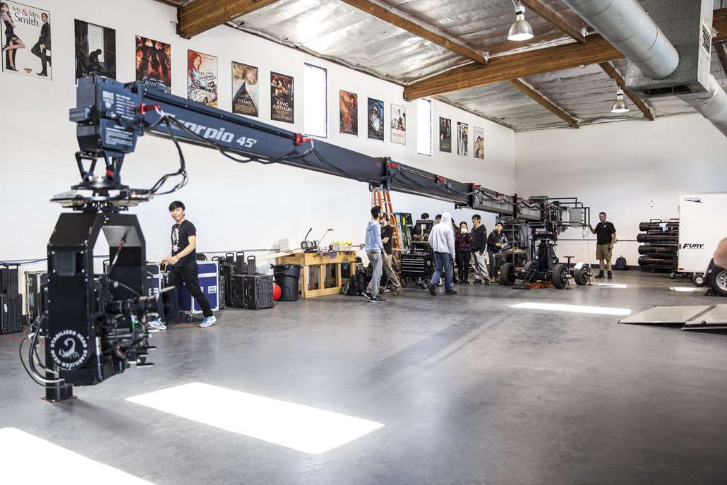 Camera crew setting up in a warehouse