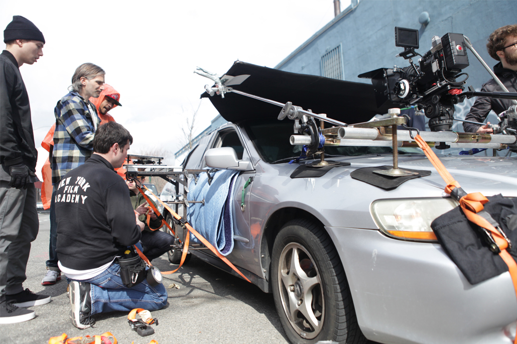 Crew members adjusting car camera rig