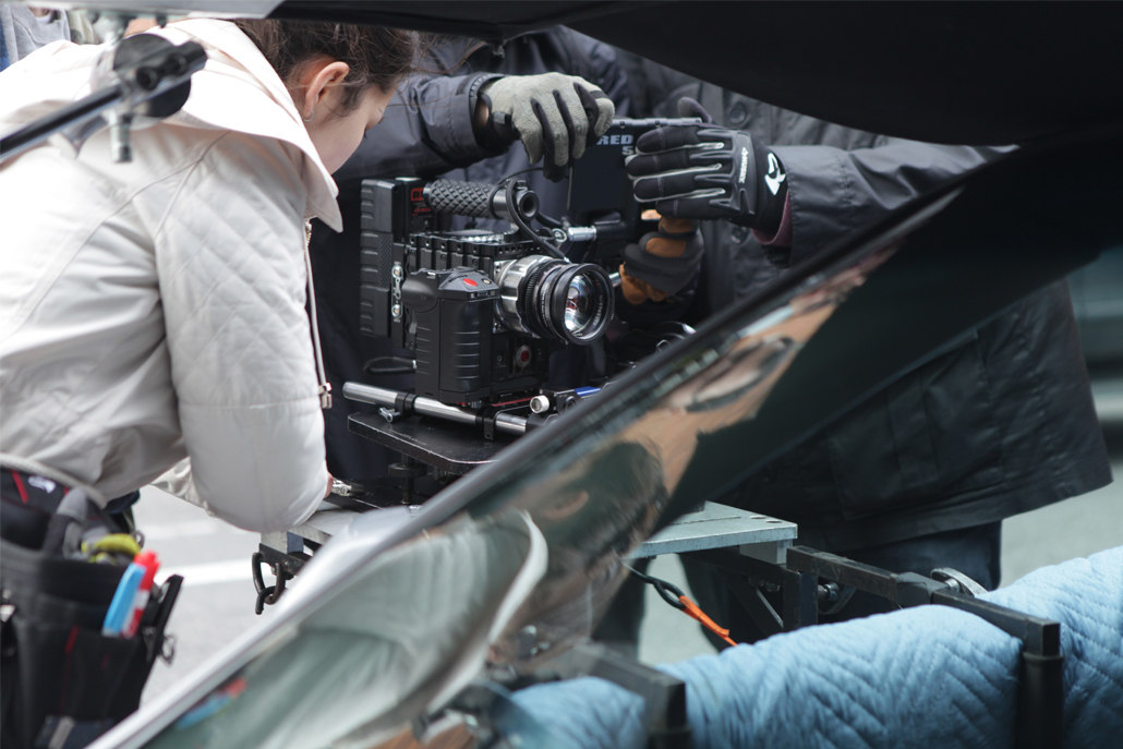 Crew members setting up camera on car rig