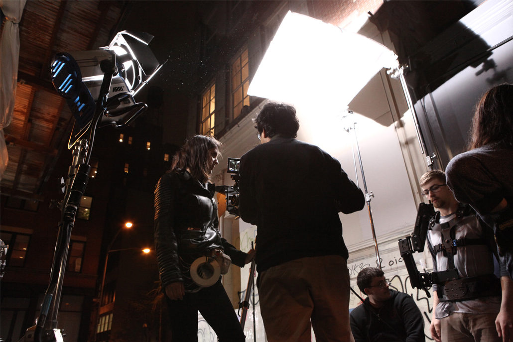 A camera crew reviewing footage in an alley