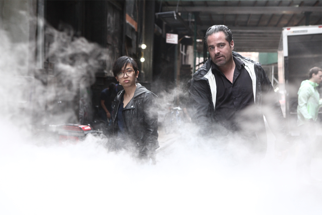 Two crew members surrounded by fog from fog machine