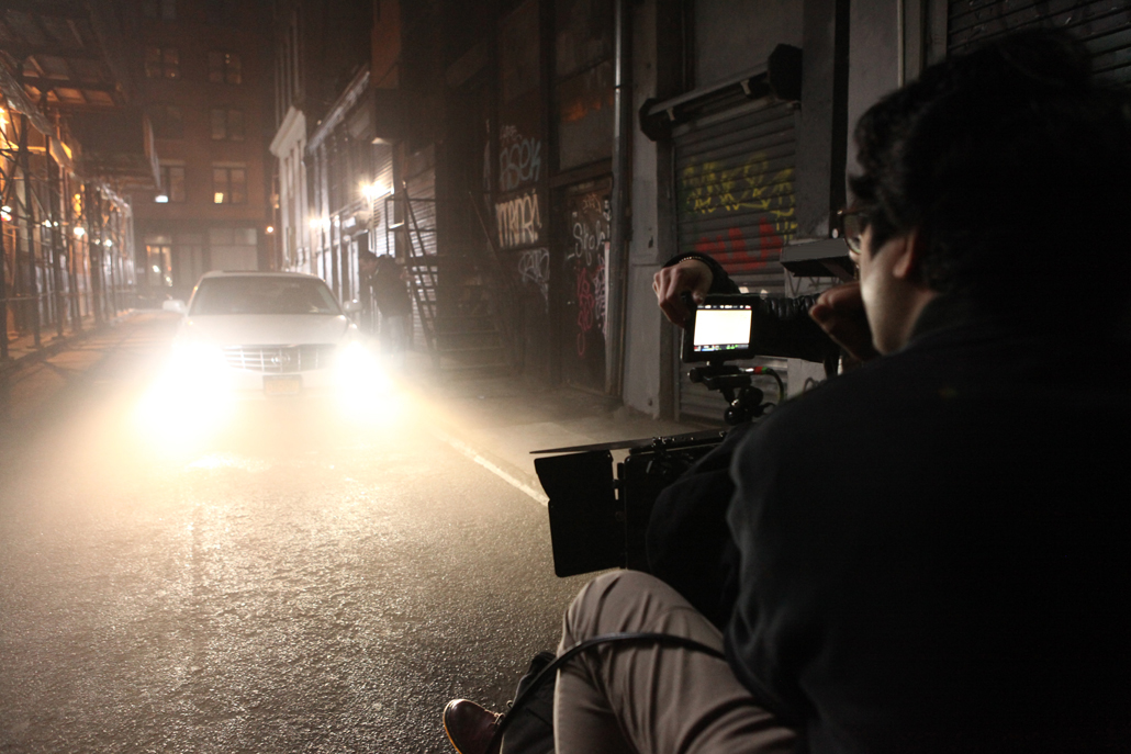 One man and a camera filming a car at night