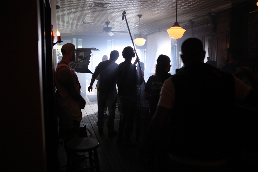 A camera crew filming in a dark bar