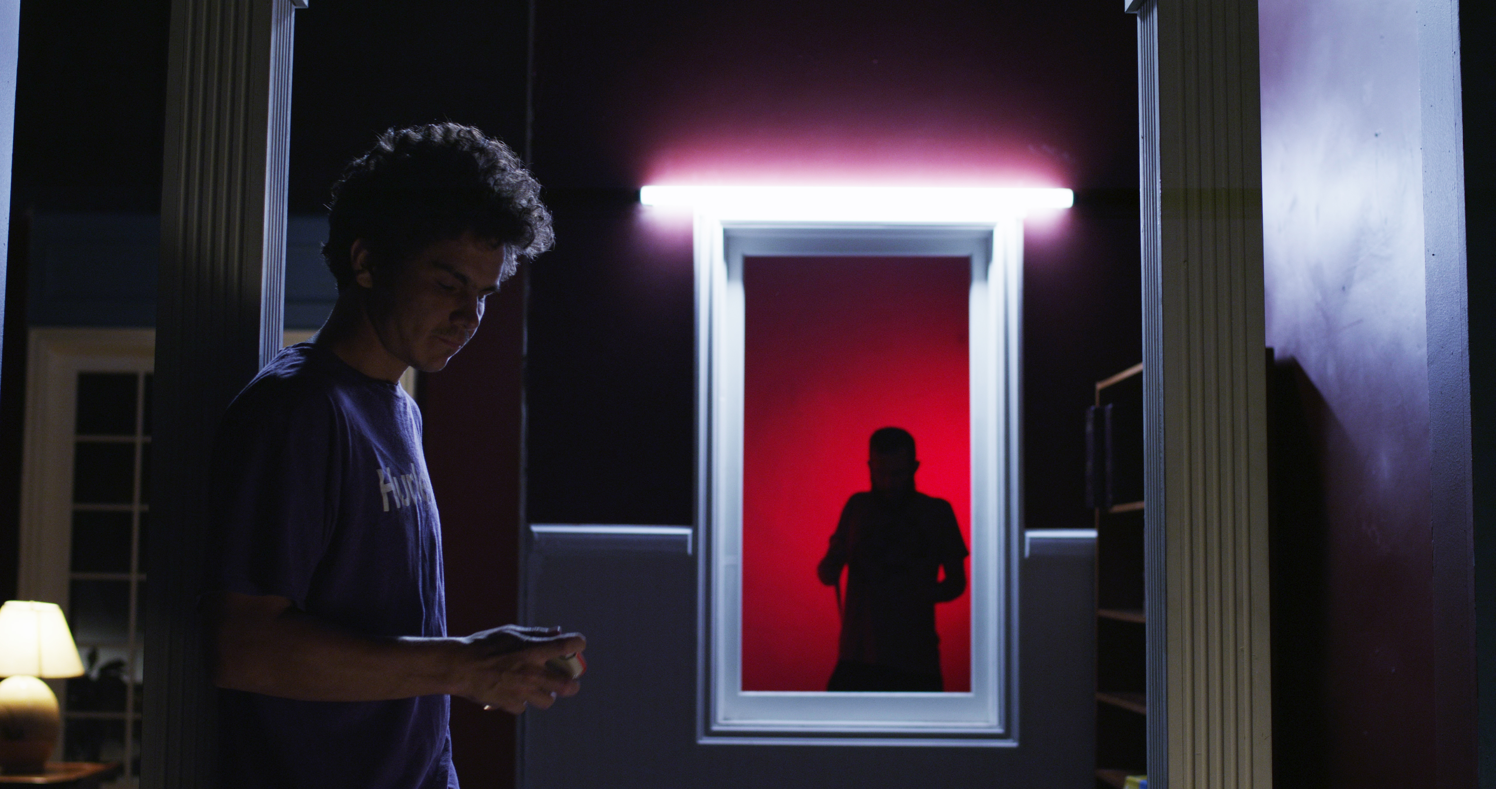 Man in a dark room holding cell phone