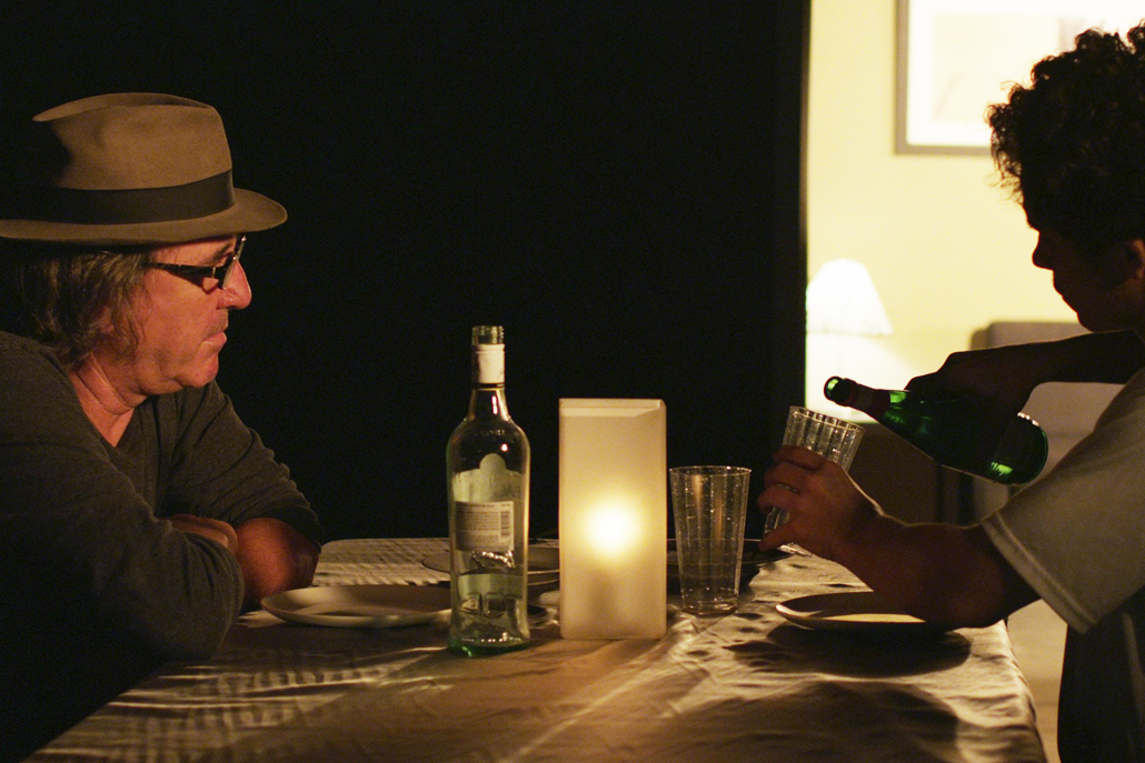 Two men pouring drinks at a table