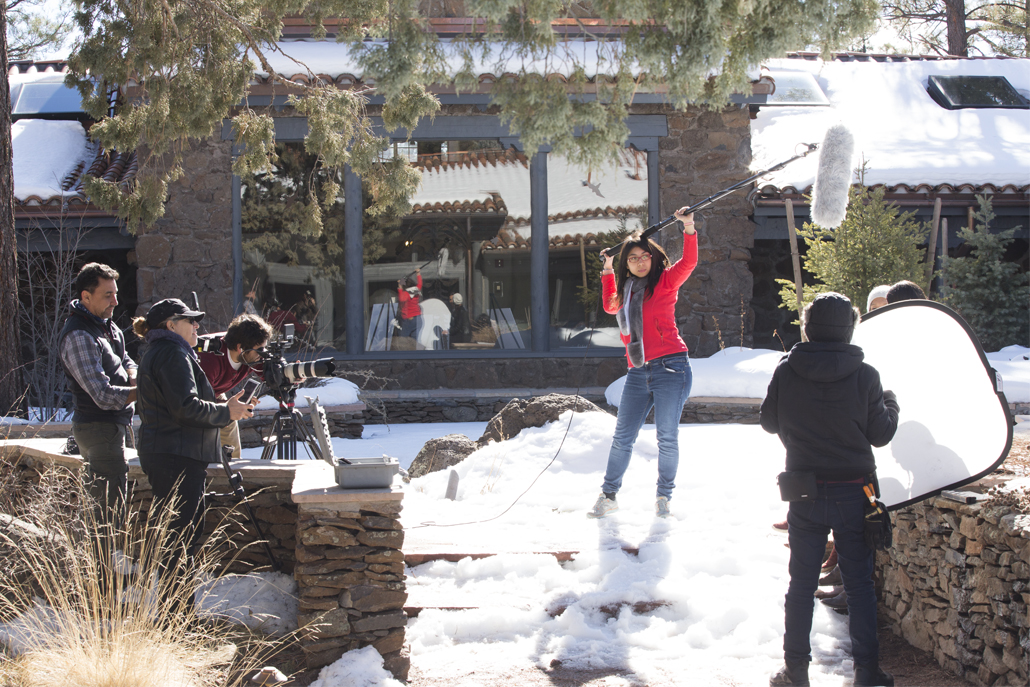 Camera crew filming in front of snowy building