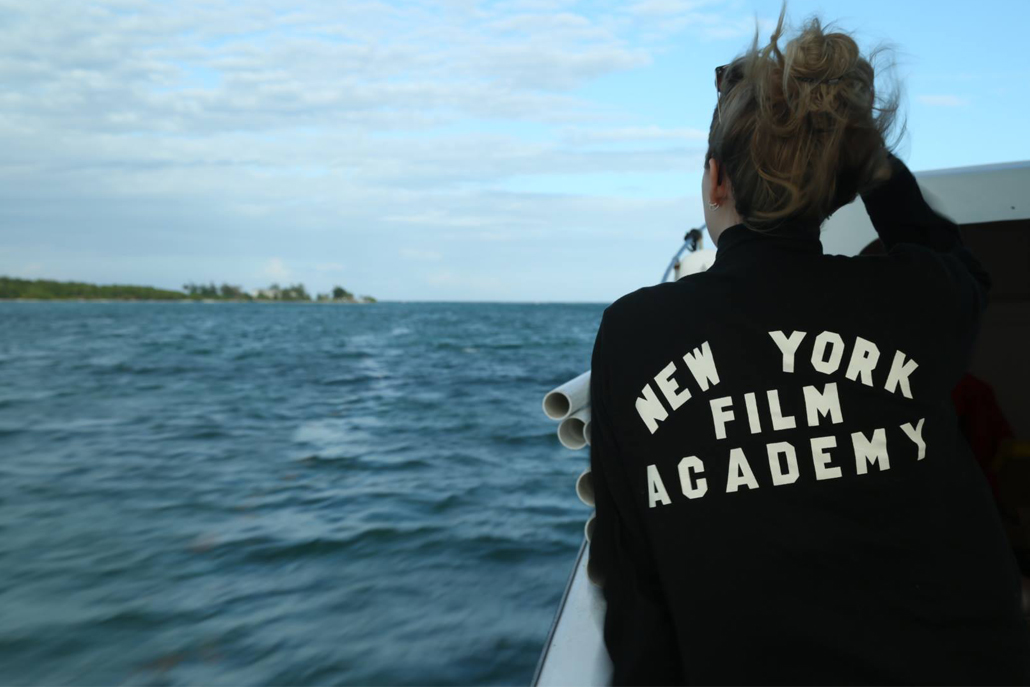 Woman on boat with 'New York Film Academy' written on back of jacket