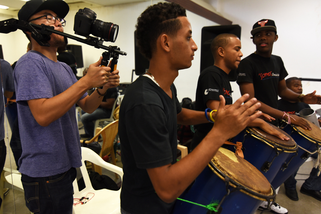 Man recording group of men drumming