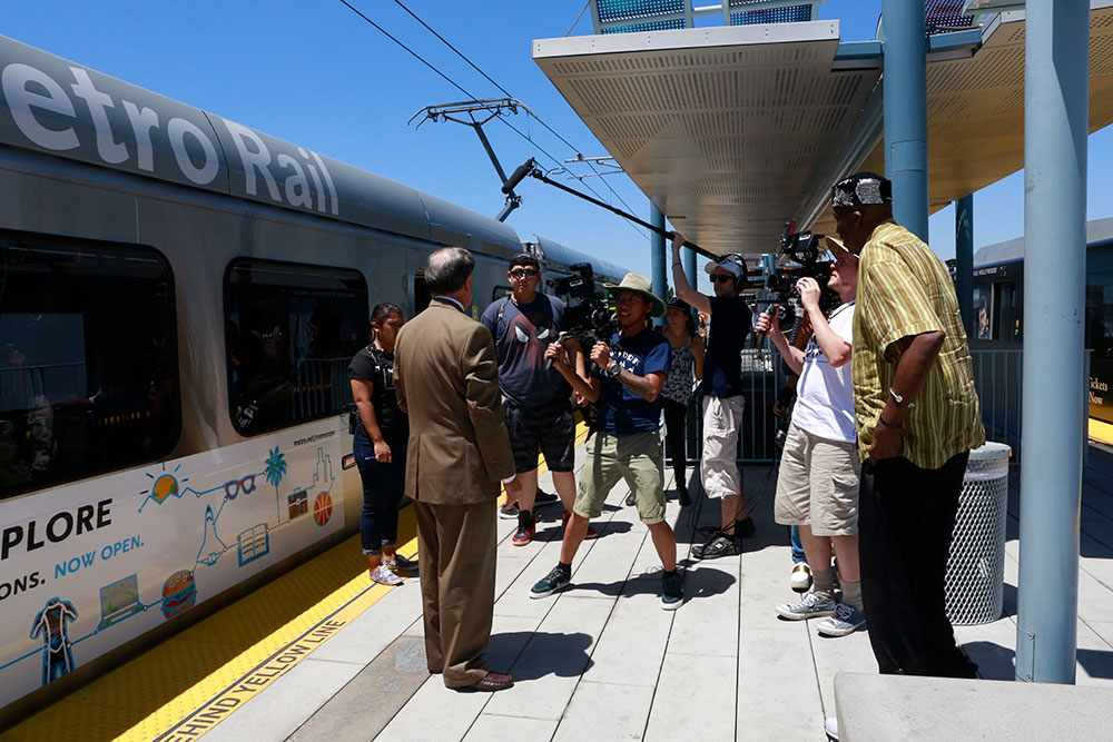 group filming man in front of metro rail