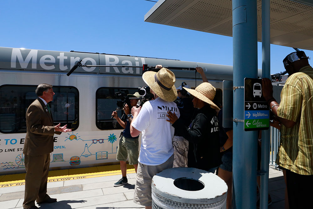 group filming man in front of metro rail