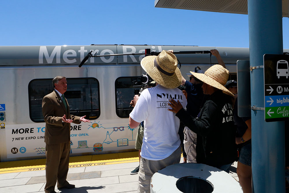 group filming man in front of metro rail