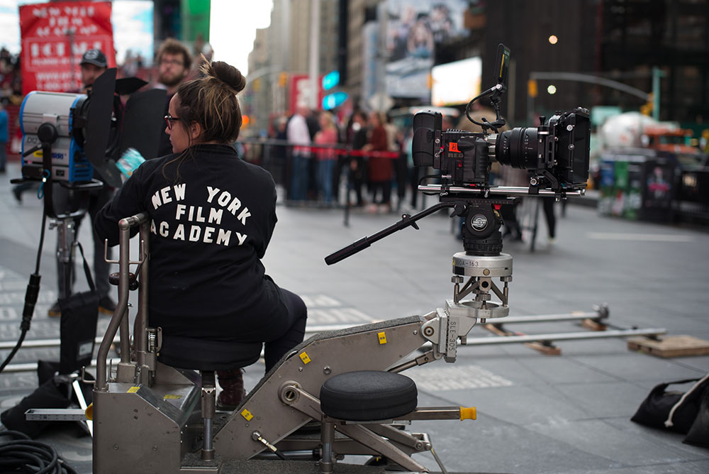 female nyfa student sitting by a camera in times square