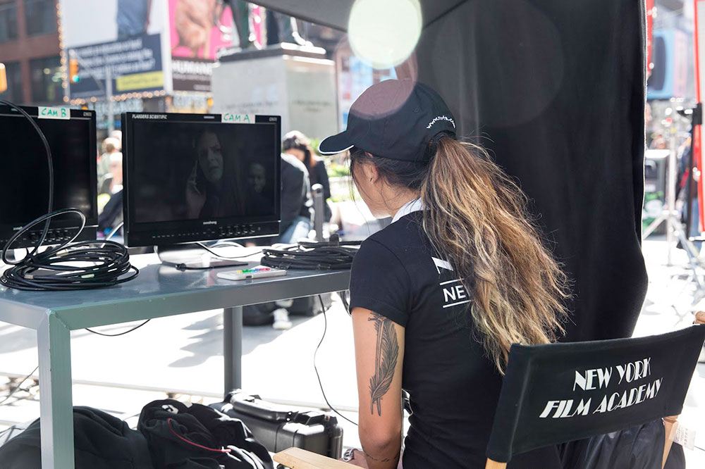 girl watching playback of scene on set