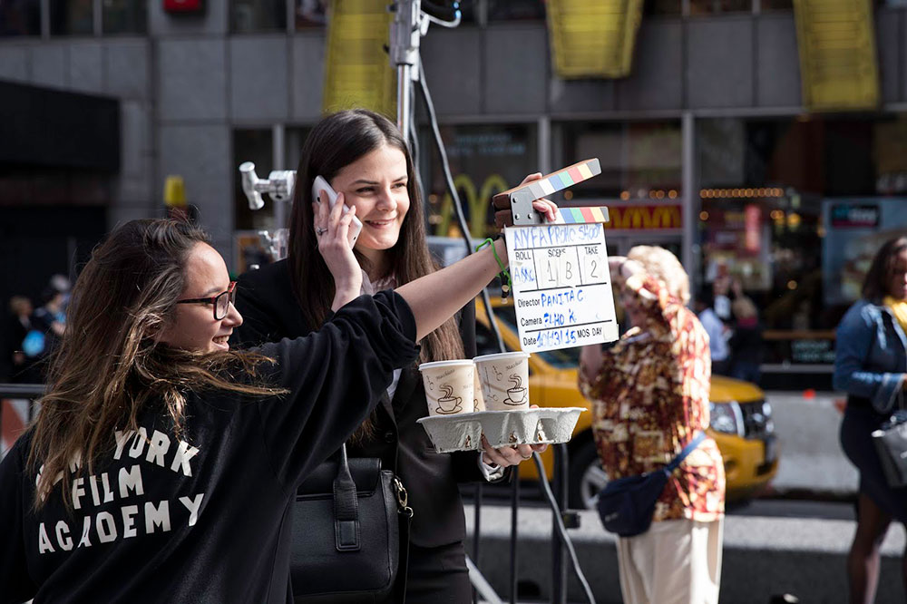 student holding a clapboard in a scene