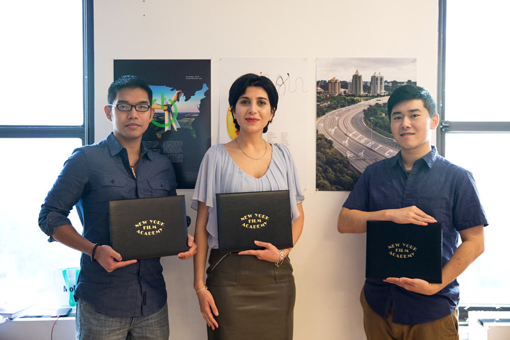 3 students holding NYFA graduation folders