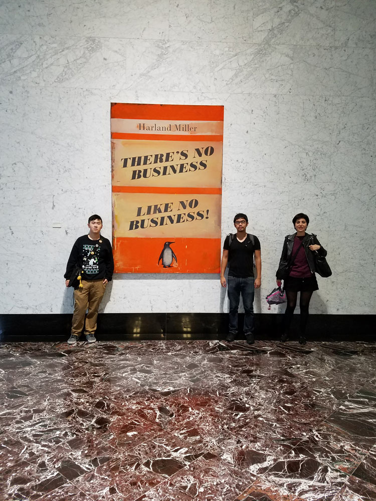 An image of 3 students with Harland Miller display 