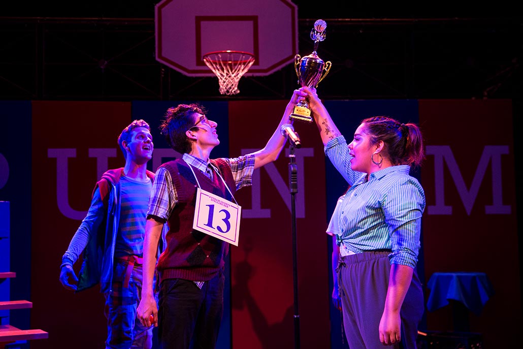 NYFA musical theatre students hold large trophy up high in Spelling Bee.