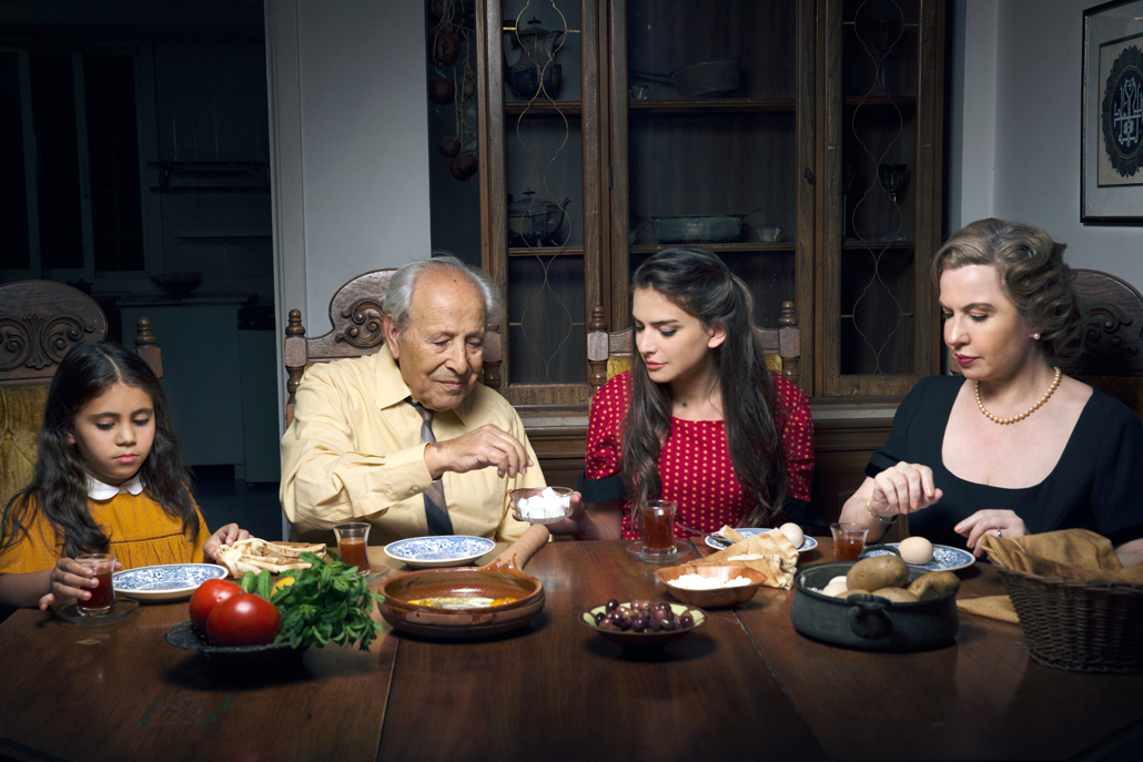 ﻿Family posing eating dinner at their dining room table