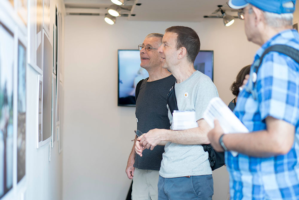 Two men viewing photos at new york film academy photo exhibit