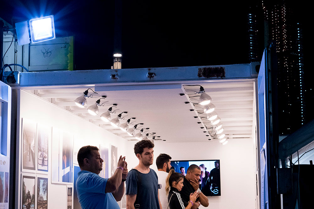 Four men and one woman viewing photos in exhibit room