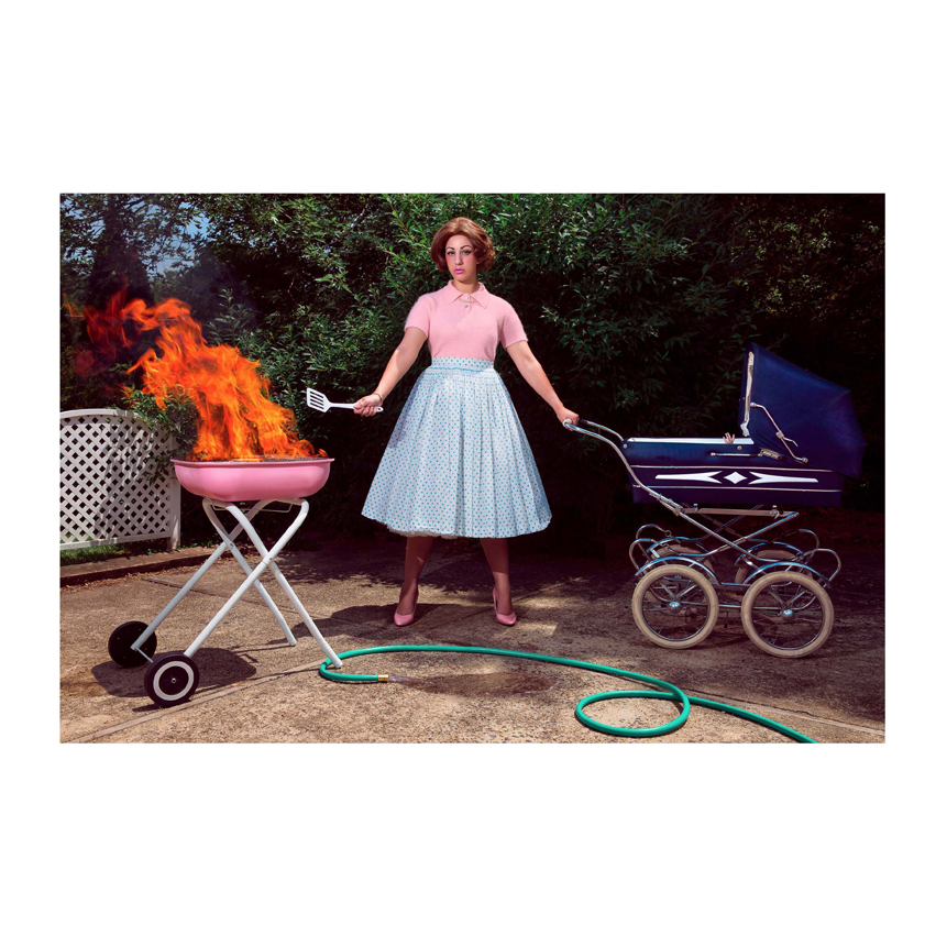 Woman pushing stroller and cooking with grill that is on fire