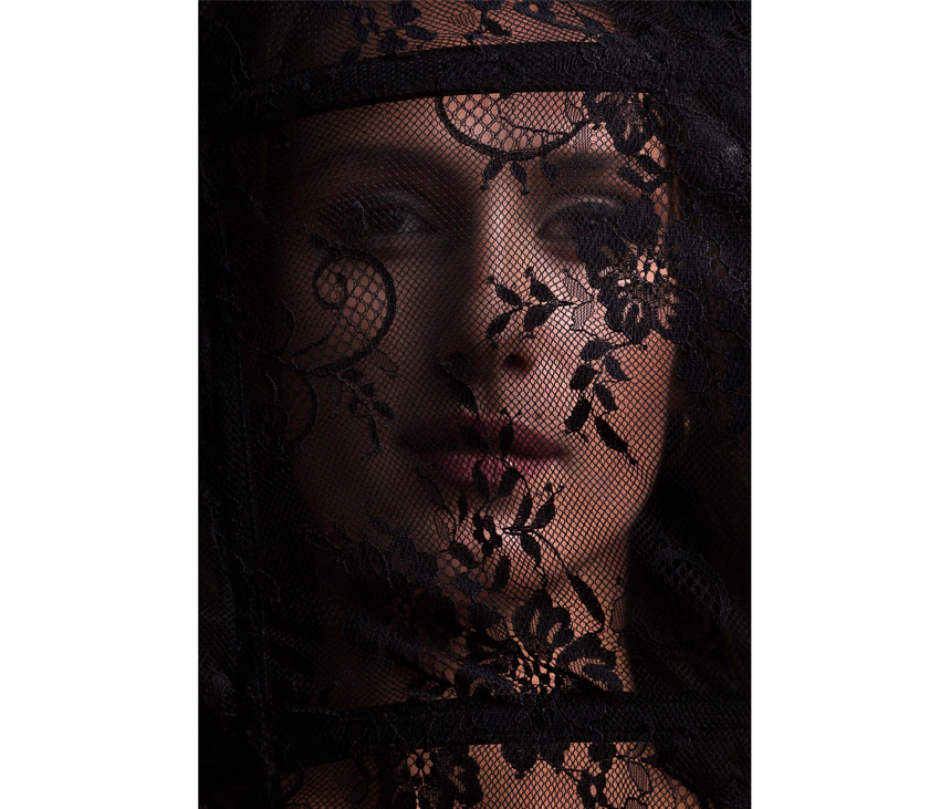 Woman's face behind black lace covering