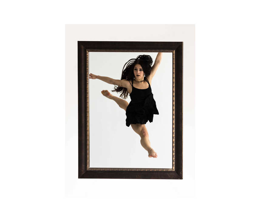 Woman in black dress dancing within black photo frame