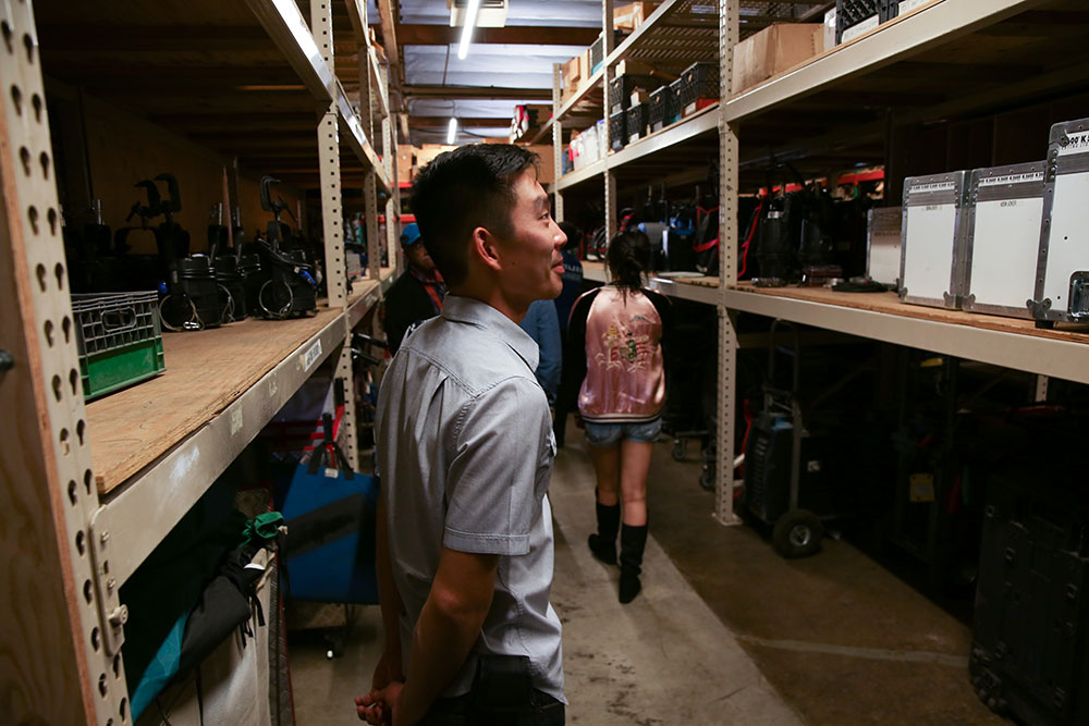 Students from NYFA class learning about film equpiment stored on shelves at Grounded Hollywood.