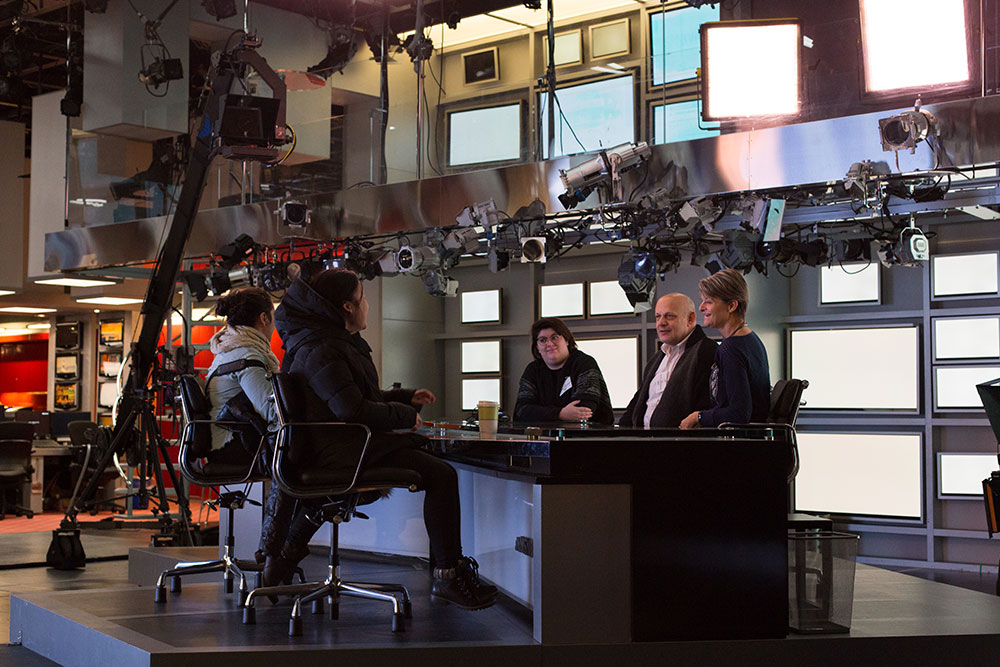group of nyfa students sitting at MSNBC News desk