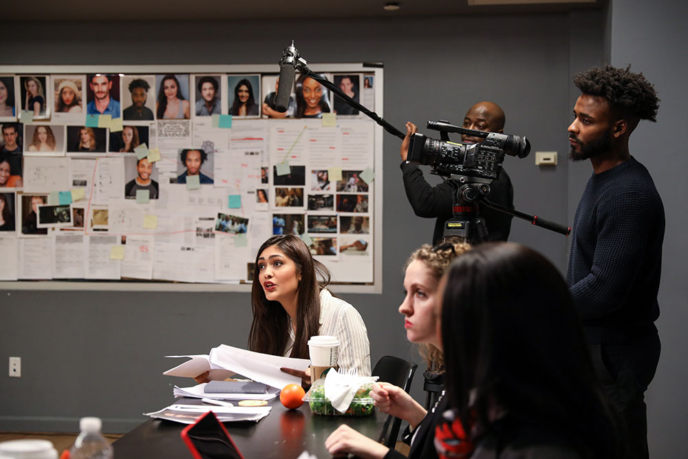 Students in a classroom performing a table-read of a script for a NYFA producing workshop.