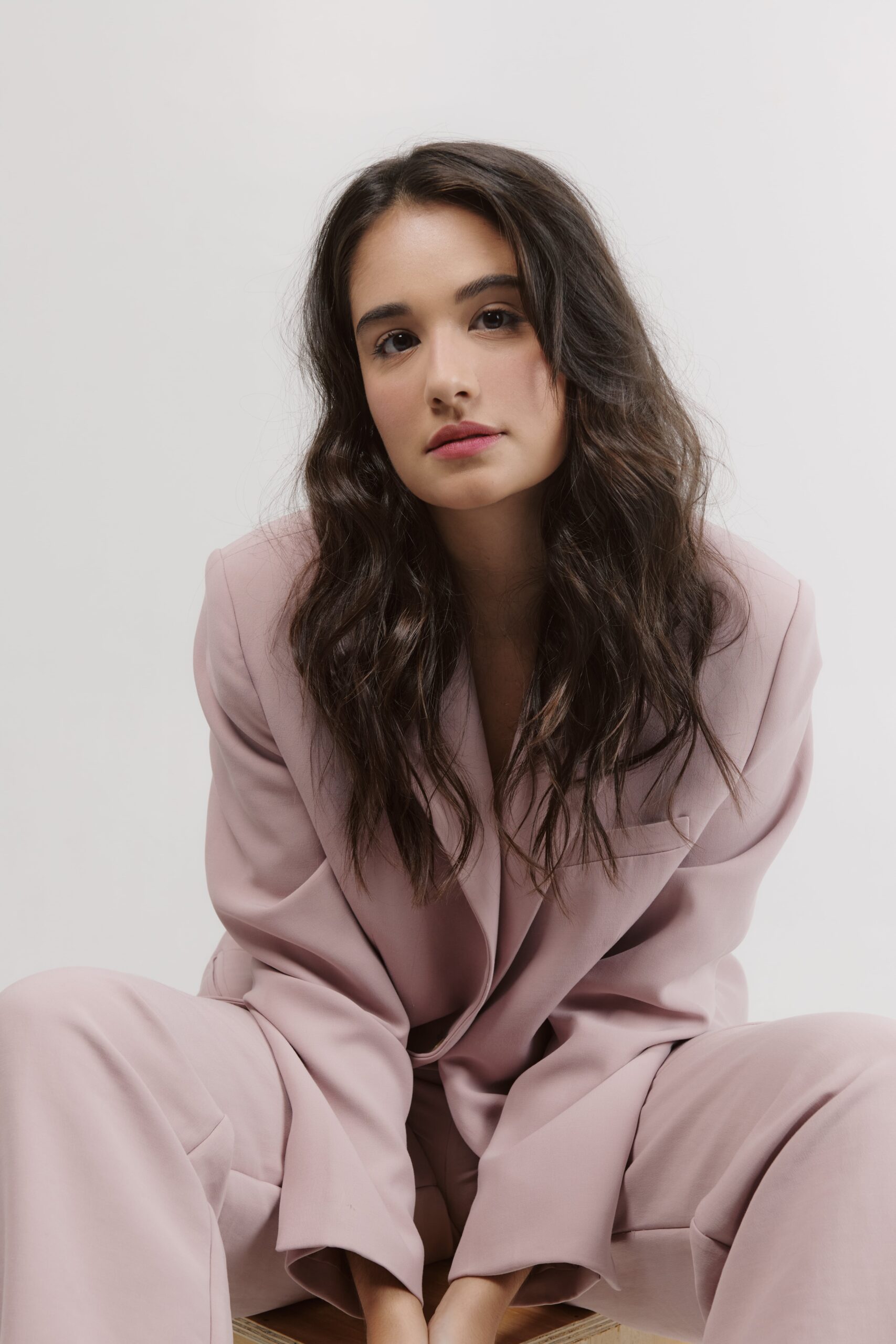 Headshot of actress Amanda Azevedo, a white female with long brown hair wearing a pale pink suit. 