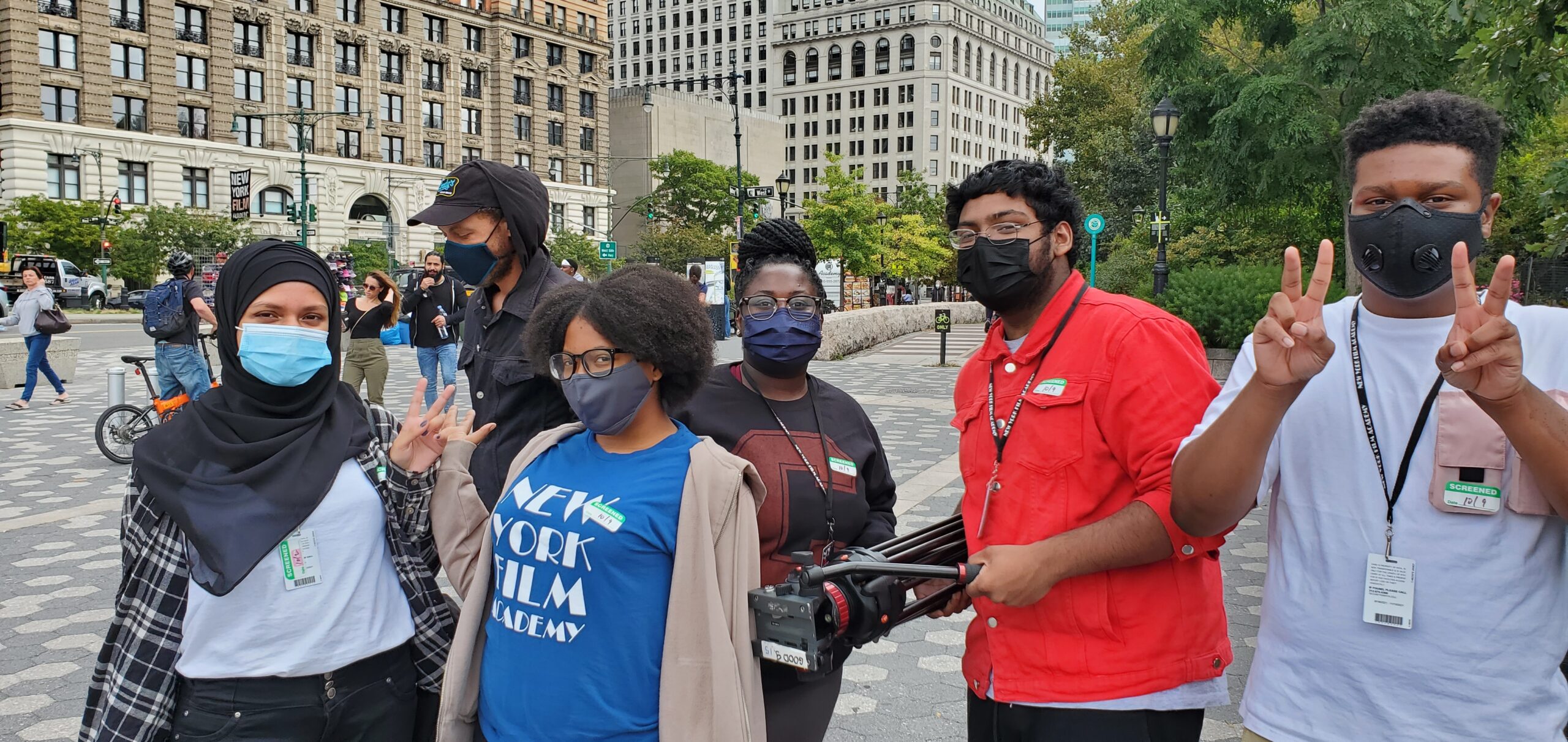 Five students from the NYFA/Dewitt Clinton 8-week digital storytelling workshop pose for a picture. One of the student is holding a camera.