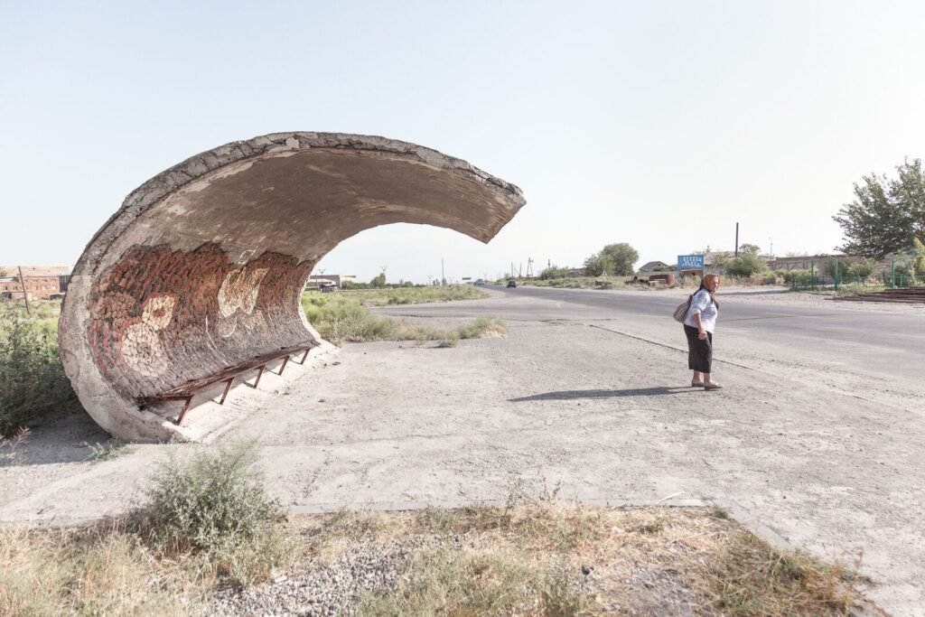 woman standing by soviet bus stop