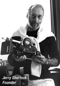 Black and white photo of Jerry Sherlock holding a film camera